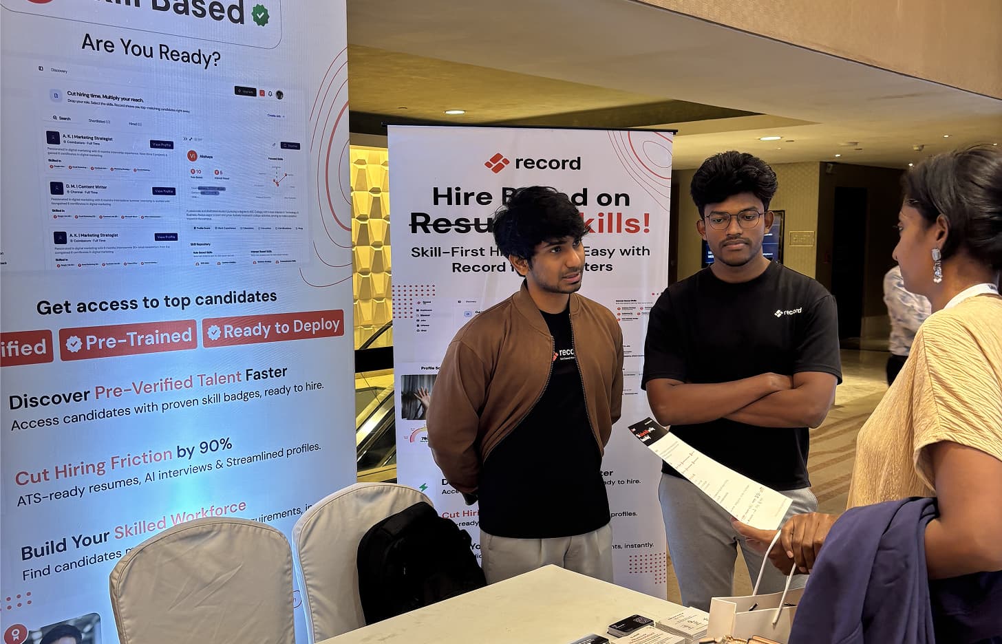 Team explaining Record to a visitor at the event booth